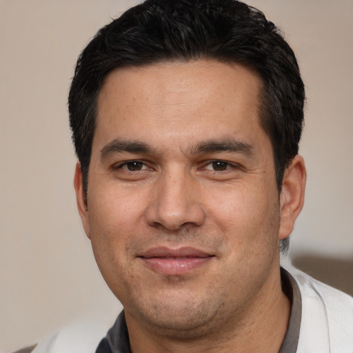 Joyful white young-adult male with short  black hair and brown eyes