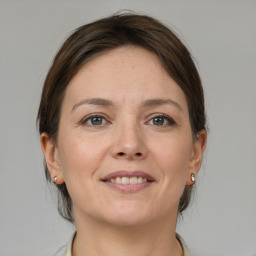 Joyful white adult female with medium  brown hair and grey eyes