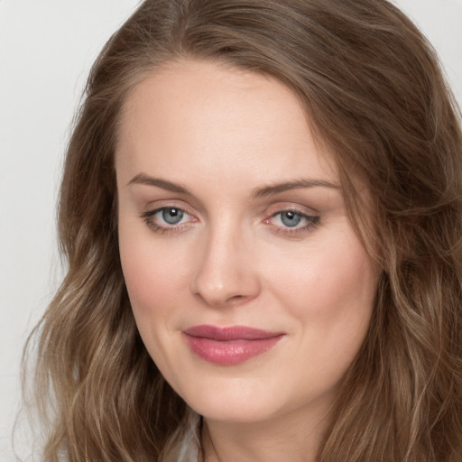 Joyful white young-adult female with long  brown hair and grey eyes