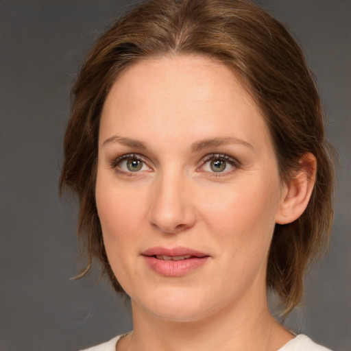 Joyful white young-adult female with medium  brown hair and green eyes