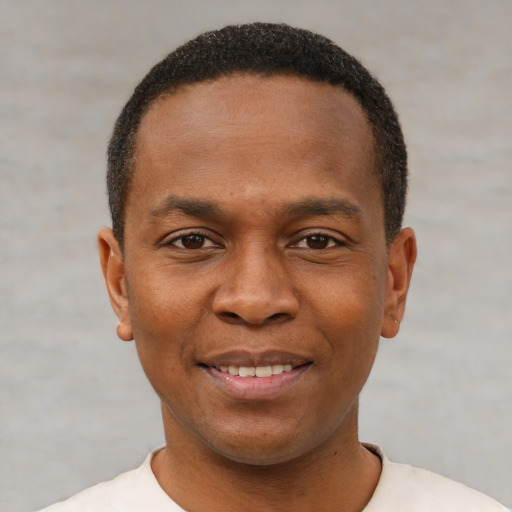 Joyful black young-adult male with short  black hair and brown eyes