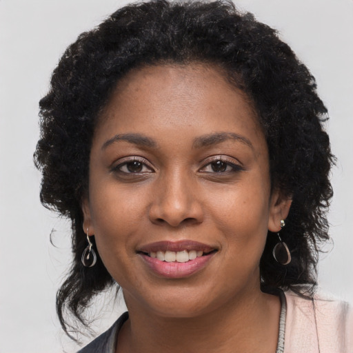Joyful black young-adult female with long  black hair and brown eyes