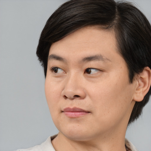 Joyful asian young-adult male with medium  brown hair and brown eyes
