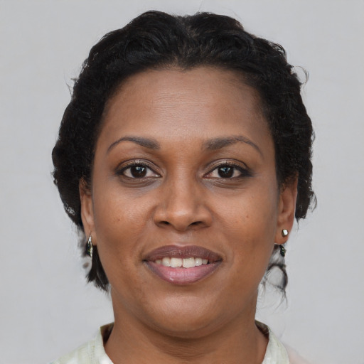Joyful black adult female with short  brown hair and brown eyes