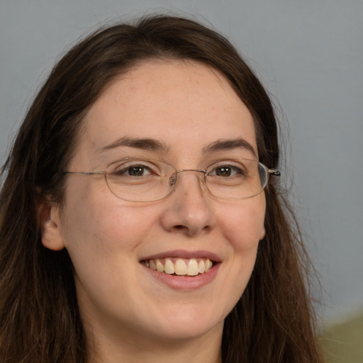 Joyful white adult female with long  brown hair and grey eyes