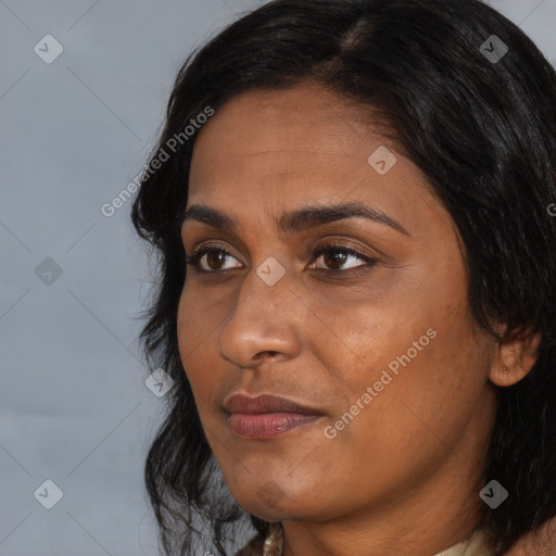 Joyful black adult female with long  black hair and brown eyes