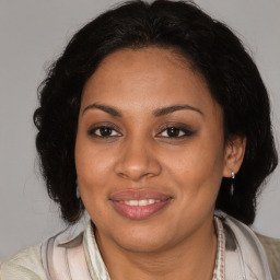 Joyful black adult female with medium  brown hair and brown eyes