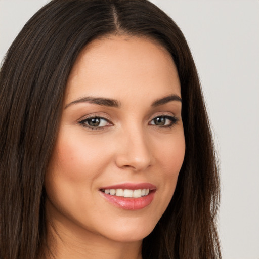 Joyful white young-adult female with long  brown hair and brown eyes