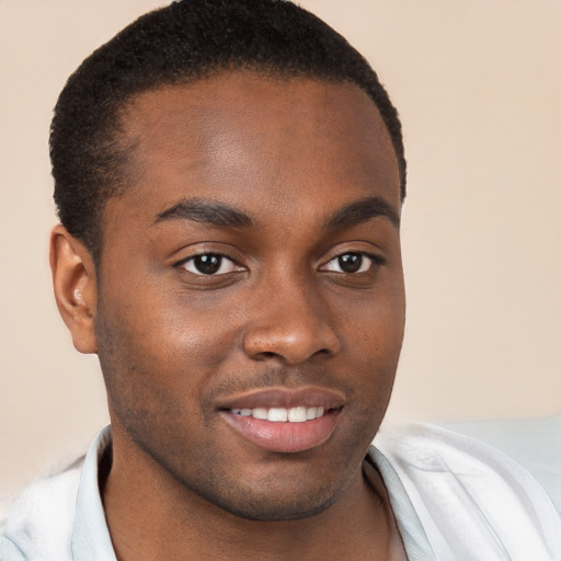 Joyful black young-adult male with short  brown hair and brown eyes