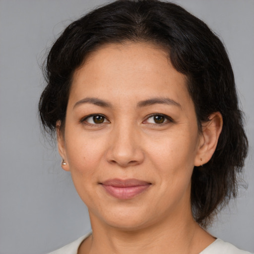 Joyful latino adult female with medium  brown hair and brown eyes