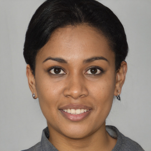 Joyful black young-adult female with short  black hair and brown eyes