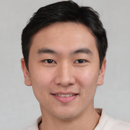 Joyful asian young-adult male with short  brown hair and brown eyes