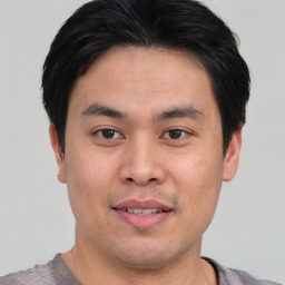 Joyful asian young-adult male with short  brown hair and brown eyes