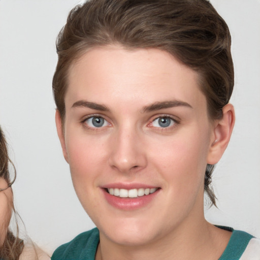 Joyful white young-adult female with medium  brown hair and blue eyes