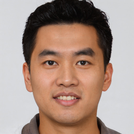 Joyful asian young-adult male with short  black hair and brown eyes