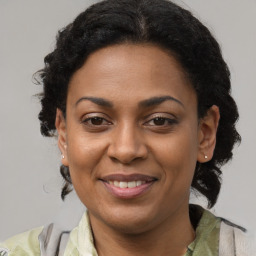 Joyful black adult female with medium  brown hair and brown eyes