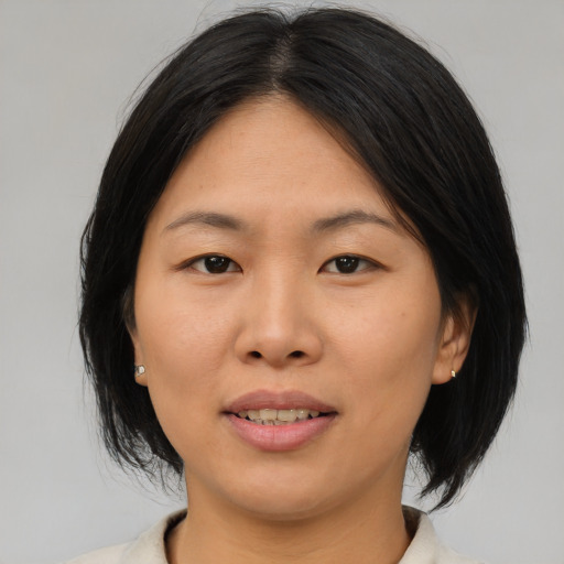 Joyful asian adult female with medium  brown hair and brown eyes