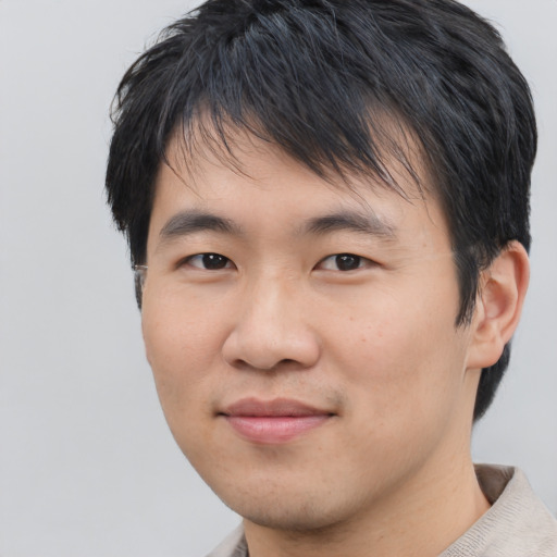 Joyful asian young-adult male with short  black hair and brown eyes