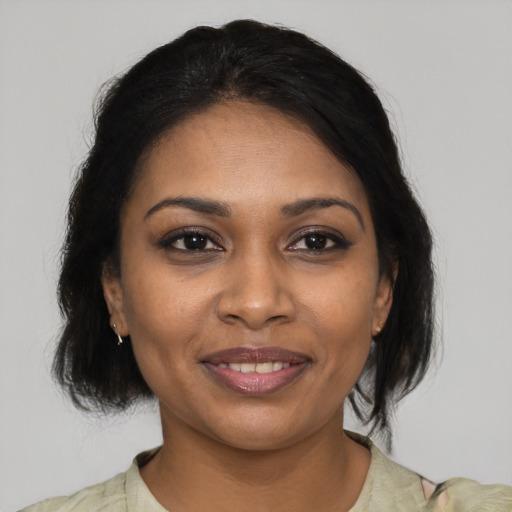 Joyful black young-adult female with medium  brown hair and brown eyes