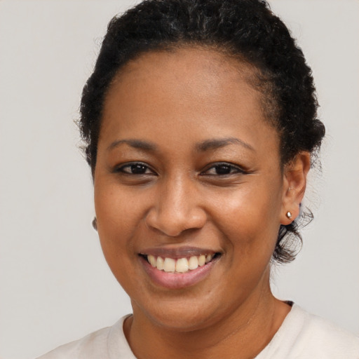 Joyful black young-adult female with short  brown hair and brown eyes