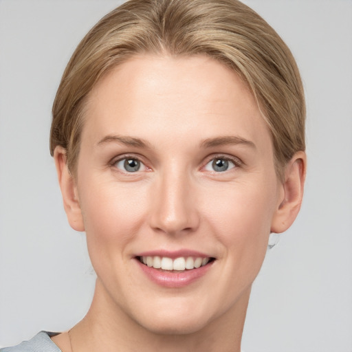 Joyful white young-adult female with short  brown hair and grey eyes