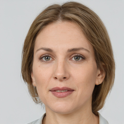 Joyful white adult female with medium  brown hair and grey eyes