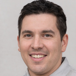 Joyful white adult male with short  brown hair and brown eyes