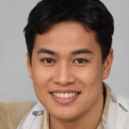 Joyful asian young-adult male with short  brown hair and brown eyes