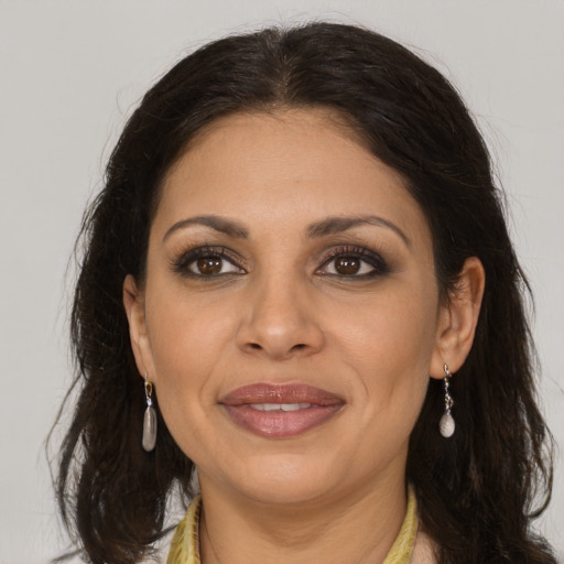 Joyful latino adult female with medium  brown hair and brown eyes