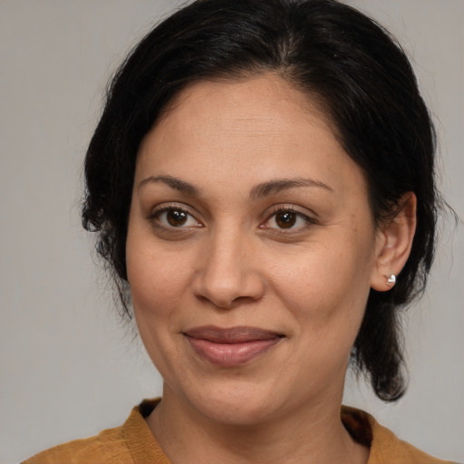 Joyful latino adult female with medium  brown hair and brown eyes