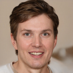 Joyful white adult male with short  brown hair and grey eyes