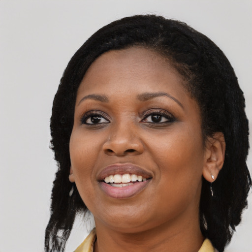 Joyful black young-adult female with long  black hair and brown eyes