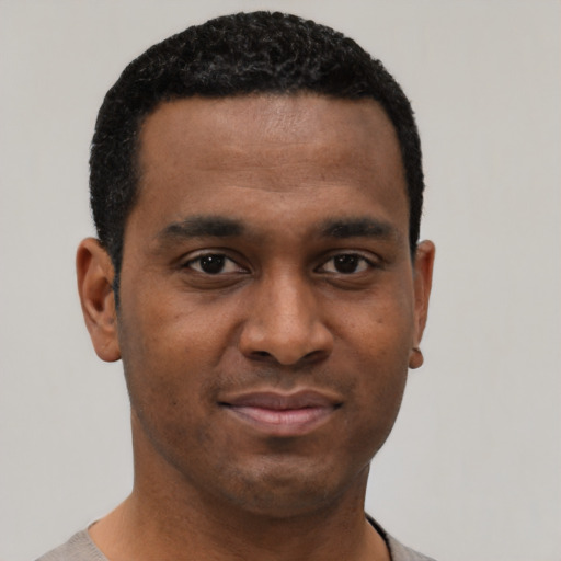 Joyful black young-adult male with short  black hair and brown eyes