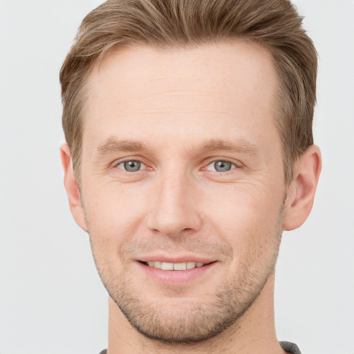 Joyful white adult male with short  brown hair and grey eyes