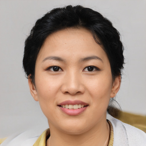 Joyful asian young-adult female with short  black hair and brown eyes