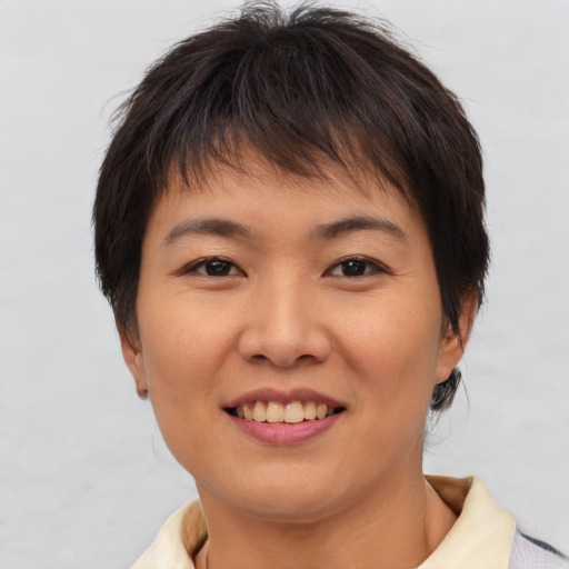 Joyful asian young-adult female with short  brown hair and brown eyes