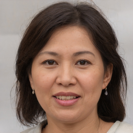 Joyful white adult female with medium  brown hair and brown eyes