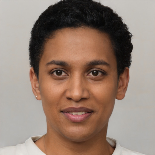 Joyful black young-adult female with short  black hair and brown eyes