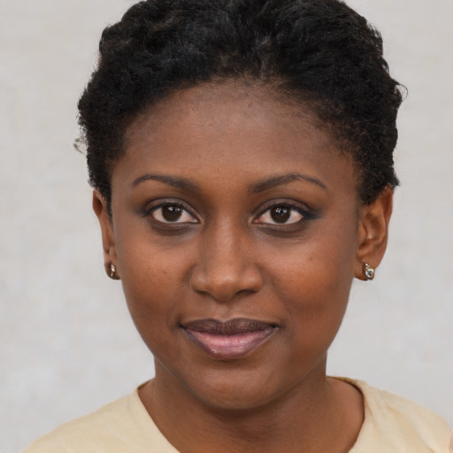 Joyful black young-adult female with short  brown hair and brown eyes