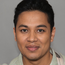 Joyful latino young-adult male with short  brown hair and brown eyes