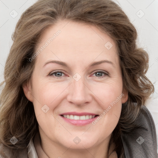 Joyful white adult female with long  brown hair and grey eyes