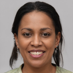 Joyful latino young-adult female with medium  brown hair and brown eyes