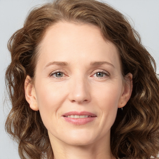 Joyful white adult female with long  brown hair and grey eyes