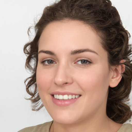 Joyful white young-adult female with medium  brown hair and green eyes