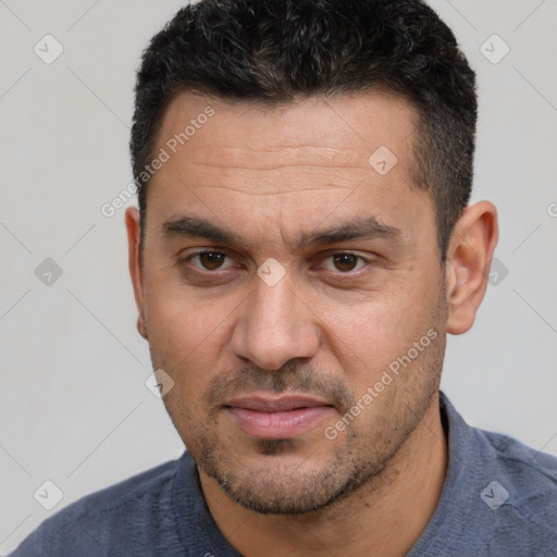 Joyful white adult male with short  black hair and brown eyes