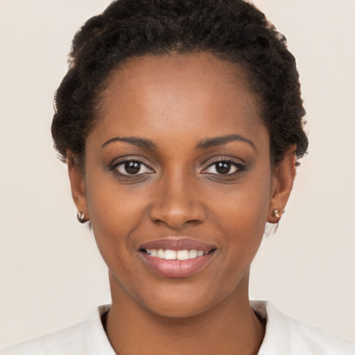 Joyful black young-adult female with short  brown hair and brown eyes