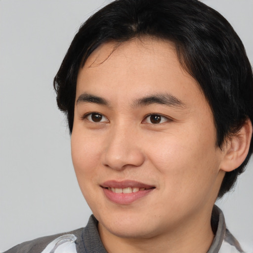 Joyful asian young-adult male with medium  brown hair and brown eyes