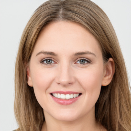 Joyful white young-adult female with long  brown hair and green eyes