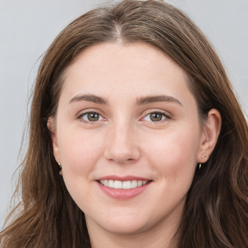 Joyful white young-adult female with long  brown hair and blue eyes