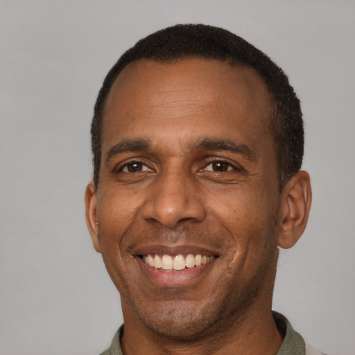 Joyful latino adult male with short  brown hair and brown eyes